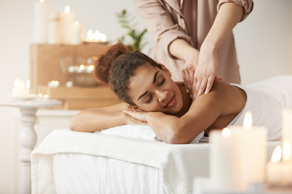 tender-african-woman-smiling-enjoying-massage-with-closed-eyes-spa-resort